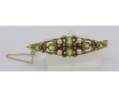 Antique style 9ct peridot and pearl hinged bangle, with engraved herringbone detail, 17.8g 