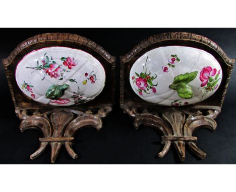A pair of 19th century French carved wood brackets with fleur-de-lis, each incorporating floral ceramic panels 