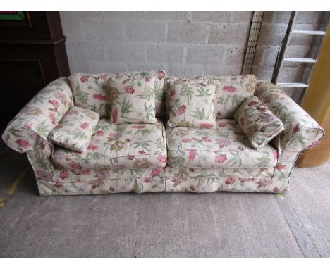 A traditional sofa with rolled arms, cream floral upholstery and loose seat and back cushions, approx 205cm long 
