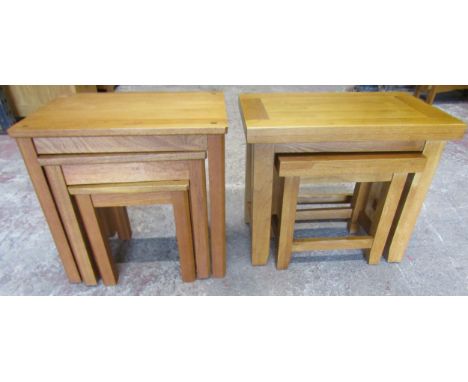 A nest of two graduated light oak  occasional tables raised on square cut and slightly shaped supports, the outer table 50 cm