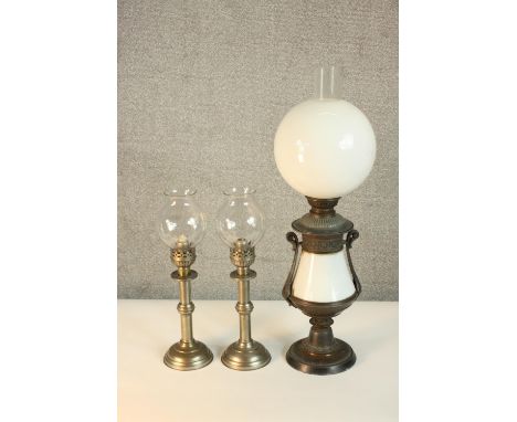 A pair of Victorian silver plated candlesticks, with glass storm shades, together with a converted silver plated oil lamp (no