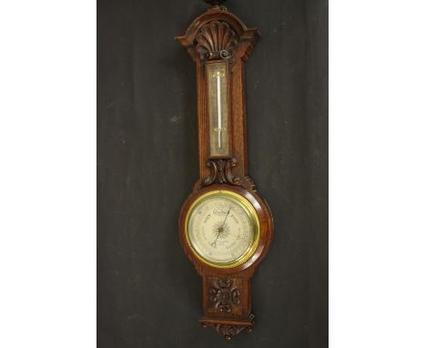 A circa 1900's Negretti &amp; Zamba carved oak barometer and thermometer with shell and flower motifs. H.67 W.18 D.8cm. 