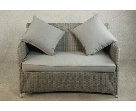 A contemporary grey painted Lloyd Loom style two seater sofa, with loose grey upholstered seat cushion and two matching scatt