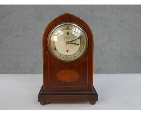 An early 20th century Smith Electric mahogany lancet form mantel clock, the case with marquetry inlay, the silvered dial with