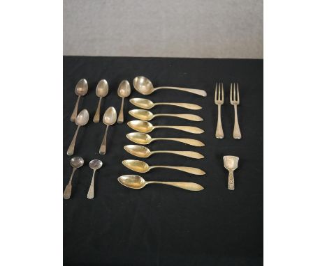 A collection of silver cutlery, including an Ionian silver caddy spoon, a set of seven German gilded silver grapefruit spoons