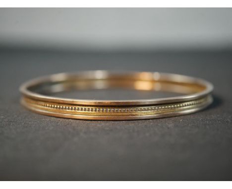 An antique 9ct rose gold bangle with beaded design around the middle with a rope design either side. Stamped 9ct. Weight 9.64