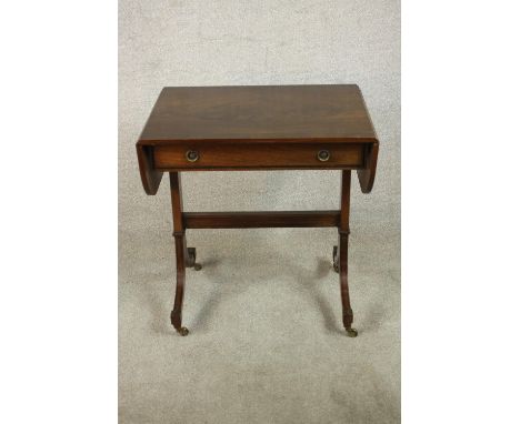 A reproduction George III style mahogany sofa table with a crossbanded top and drop leaves over a single drawer, on end suppo