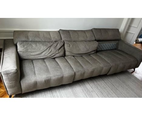 A very large contemporary Roche Bobois fully reclining sofa upholstered in grey fabric, on splayed legs. H.70 W.320 D.110cm. 