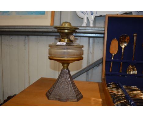A late Victorian cast iron based oil lamp with clear glass reservoir