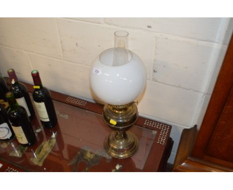 A brass oil lamp with milk glass shade