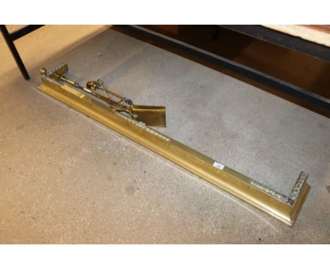 A brass fender and fire tools