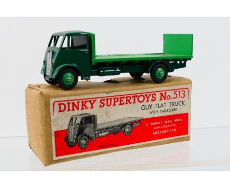 Dinky Toys - A boxed Dinky Toys #513 Guy Flat Truck. The model with 1st type cab in dark green cab, chassis and wings with mi