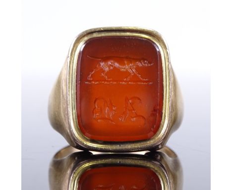 A large unmarked gold intaglio carved carnelian seal ring, with pointer dog emblem and initials A B, setting height 19.8mm, s