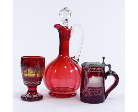 A Victorian ruby glass Claret jug, a Bohemian ruby overlay glass tankard, and a Bohemian ruby glass goblet with gilded panels