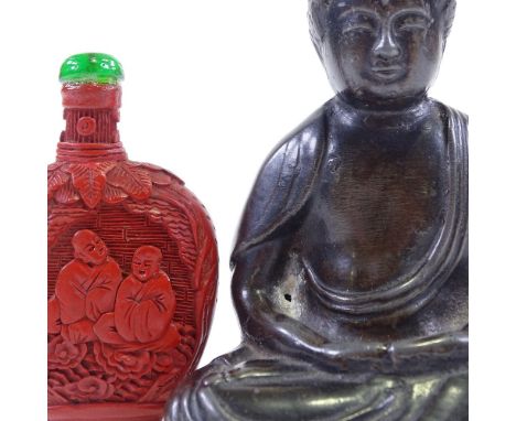 A Chinese patinated spelter seated Buddha, height 10cm, a carved cinnabar snuff bottle, and a carved and pierced jade pendant