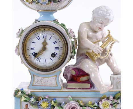 An ornate German 19th century porcelain cased mantel clock, surmounted by a musical cherub, enamel dial with 8-day movement s
