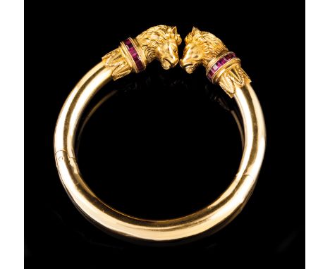 A "torc" bangle  Gold Plain with two chased lion heads with square cut ruby collars Possibly Portuguese, second quarter of th