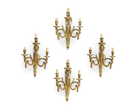 Suite de quatre appliques Louis XVI en bronze ciselé et doré à trois bras de lumière, début XIXe siècleA suite of four late L