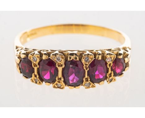 A five stone ruby ring, a scroll carved half hoop ring set with five graduated oval-cut rubies, each ruby is interspaced by t