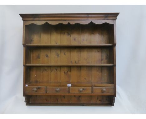 A wall hanging plate rack with integral spice drawers.