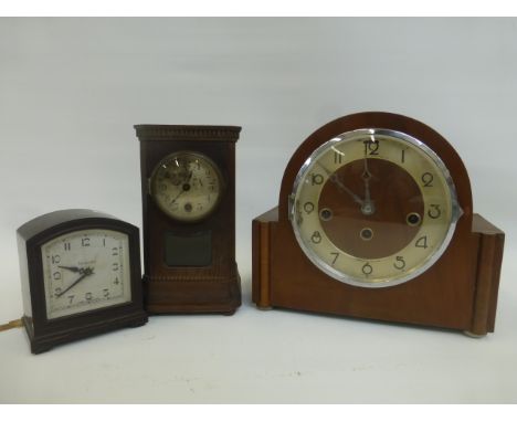 An Art Deco Genalex bakelite electric mantel clock and two wooden cased mantel clocks.