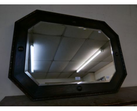A carved oak octagonal framed mirror 
