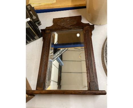 A VICTORIAN OAK FRAMED BEVELLED WALL MIRROR WITH SHELF 