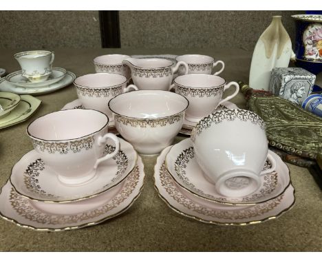 A COLCLOUGH CHINA TEASET IN PALE PINK AND GILT TO INCLUDE A CAKE PLATE, SUGAR BOWL, CREAM JUG, CUPS, SAUCERS AND SIDE PLATES