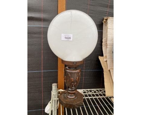 AN OAK CARVED TABLE LAMP WITH OPAQUE GLASS SHADE 