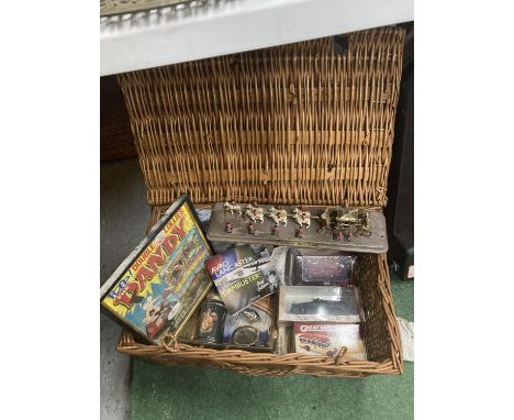 A BASKET CONTAINING SEVERAL ITEMS TO INCLUDE A FRAMED DANDY COMIC, AN UNOPENED BOXED ATLAS EDITION FIRE ENGINE, TANK, BUS AND