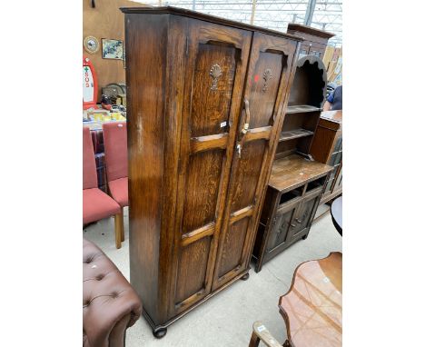 AN EARLY 20TH CENTURY OAK PANELLED TWO DOOR WARDROBE WITH INTERIOR MIRROR ON BUN FEET, 38" WIDE 