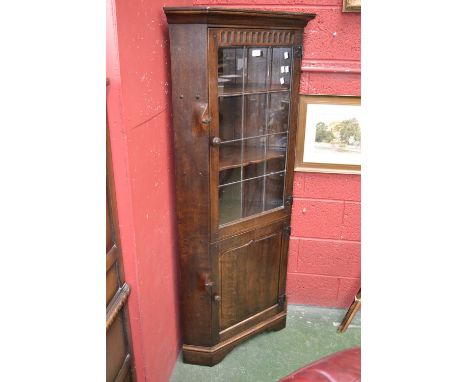A Monastic oak floor standing corner cabinet, with glazed leaded light