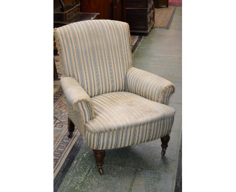 A Victorian walnut armchair, in the manner of  Howard & Sons, stuffed-over upholstery, turned legs, ceramic casters, 82cm wid