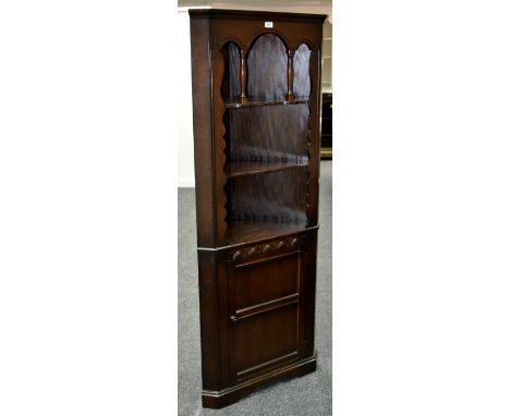 A contemporary oak floor standing corner cupboard, open shelving to top, panel door cupboard to base.