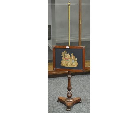 A Victorian pole screen, woolwork panel brass pole, turned mahogany column, triform base, bun feet.