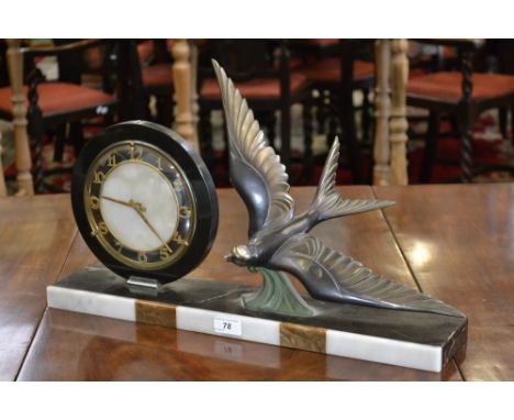 A 1930's Art Deco mantel clock, having a circular face beside a swooping swallow on a marble base.