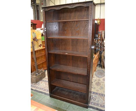 An oak six shelf large bookcase with carved top