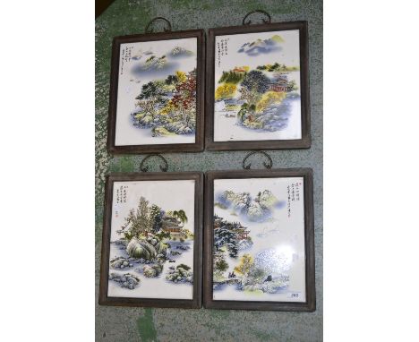 A set of four Chinese ceramic wall plaques depicting country scenes.