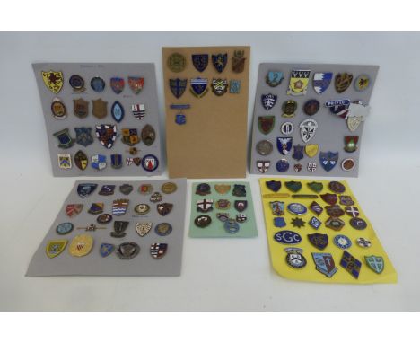 A collection of early 20th Century school and college badges including silver and enamel, all mounted on six cards, approxima