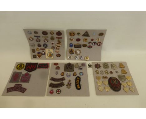 Four cards displaying assorted cloth, enamel and metal badges including W.I., A.R.P., W.V.S., National Savings, etc.