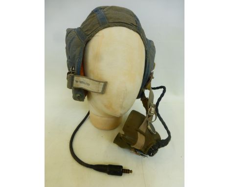 An Air Force pilot's helmet, size 3 bearing label dated 1954, complete with mouthpiece and connecting cable.