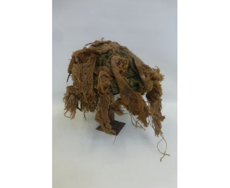 A 1980 pattern camouflaged British Army helmet with liner and chin strap.