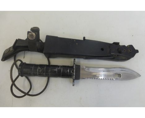 A knife/wire cutter with survival kit in the hilt, the blade approximately 5 3/4" in its scabbard.