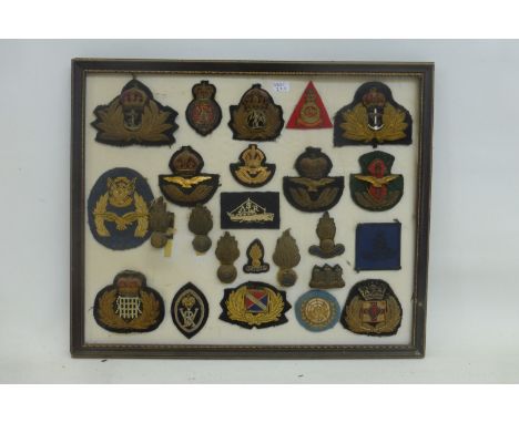 A framed display of 25  Royal Navy, Royal Air Force and British Army bullion wire badges.