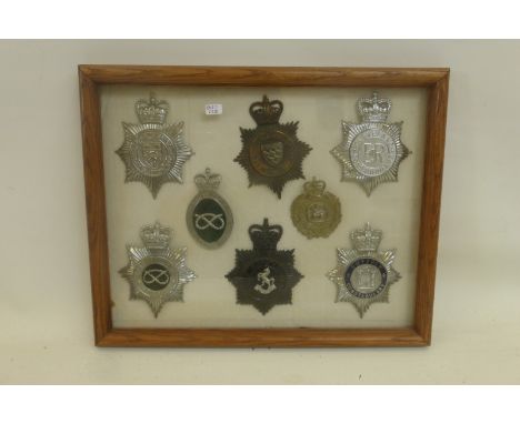 A framed and glazed display of eight police and constabulary helmet badges. Average size approximately 4 3/8 x 3 1/2". All re