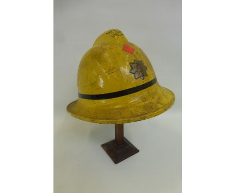A 1962 yellow fire brigade helmet with liner and chin strap.