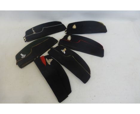 Six military side caps with staybrite badges including Royal Army Pay Corps, Royal Army Ordnance Corps, Green Howards, Royal 