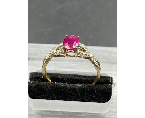 A ruby and diamond ring, oval cut ruby weighing a calculated, with ten round cut diamonds set to the crossover shoulders, wei