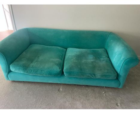 An upholstered teal velvet sofa 