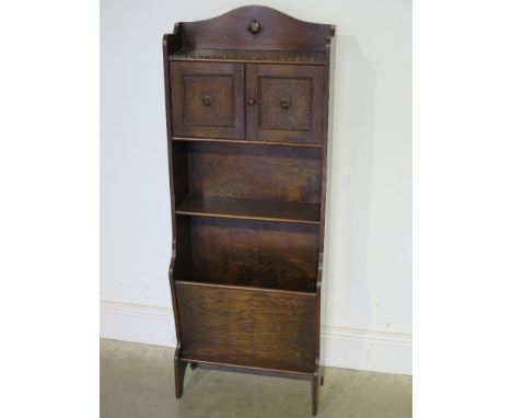 An early to mid 20th century oak cabinet gallery above beaded decoration over two doors above open shelf above magazine rack 